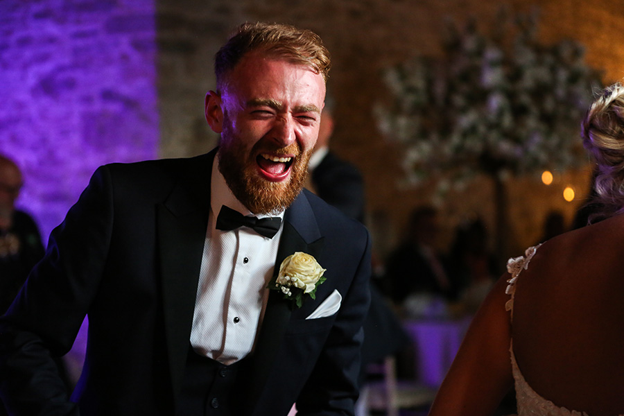 Candid wedding photography in Bournemouth capturing a groomsman laughing during the wedding day